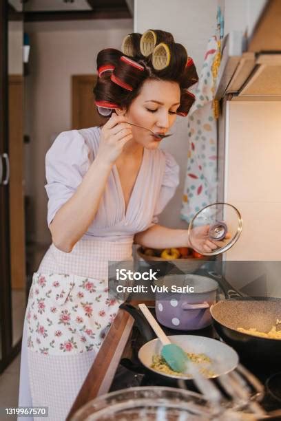 Woman Tasting The Food While Cooking Stock Photo - Download Image Now ...