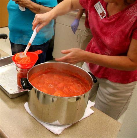 Ladling hot tomatoes into jars - Free photos on creazilla.com