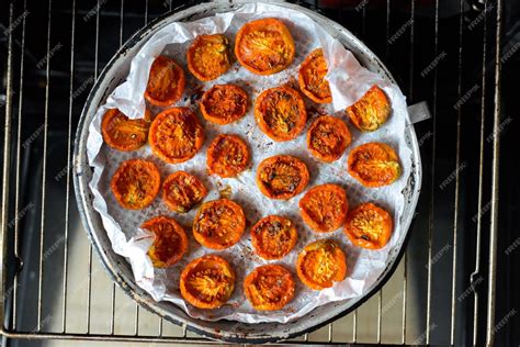 Premium Photo | Trays of fresh cherry tomatoes on racks drying in the oven
