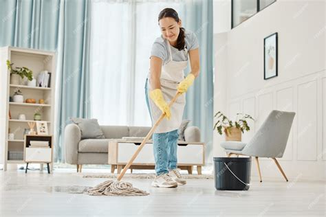 Premium Photo | Woman cleaning the floor with a mop in the living room ...