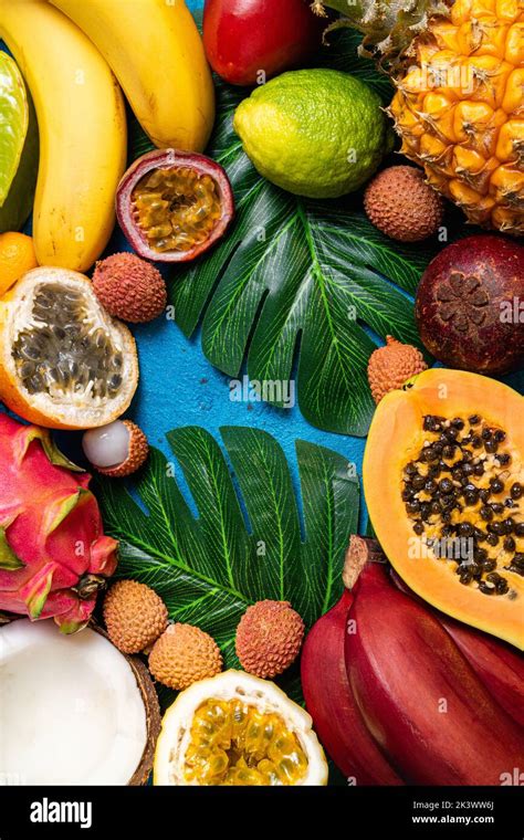 Fresh tropical fruits flat lay. Different exotic fruits on blue summer ...