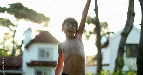 Boy raising arms in the sky clenching fists in victory and celebration ...