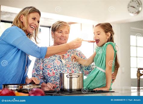 Time for a Taste Test. Shot of a Multi Generational Family Cooking ...