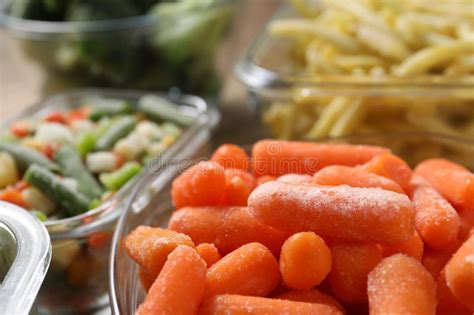 Different Frozen Vegetables in Containers on Table, Closeup Stock Image ...