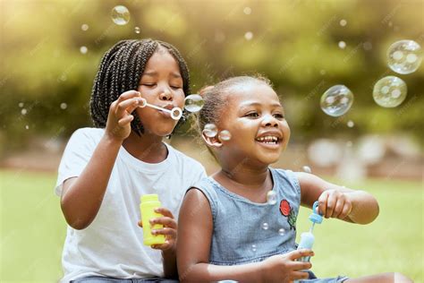 Premium Photo | Black kids children and blowing bubbles at park having ...