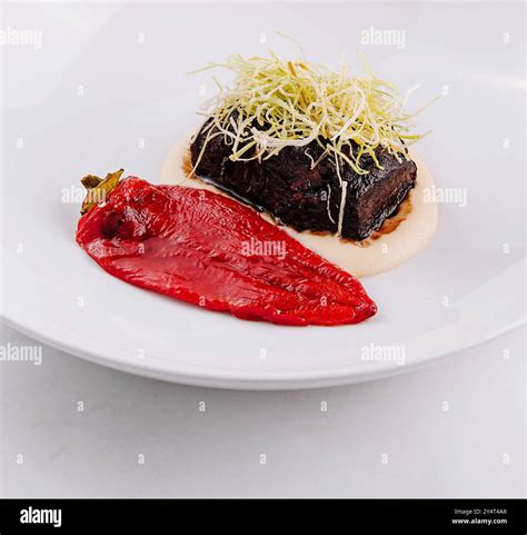 Elegant dish of tender braised beef on a smear of puree with a vibrant ...