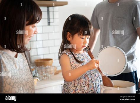 Girl and her parents helping in the kitchen Stock Photo - Alamy