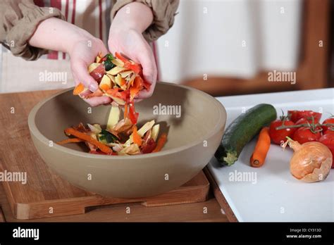 Woman putting vegetable peeling into bowl Stock Photo - Alamy