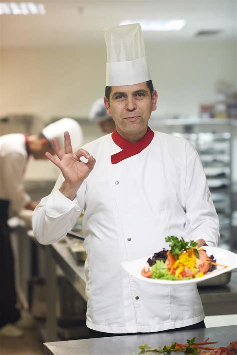 chef in hotel kitchen preparing and decorating food 12131518 Stock ...
