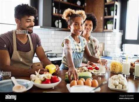 Happy family cooking together food in the kitchen Stock Photo - Alamy