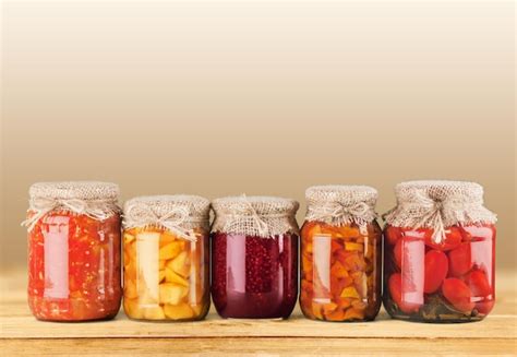 Premium Photo | Jars with canned vegetables on wooden table
