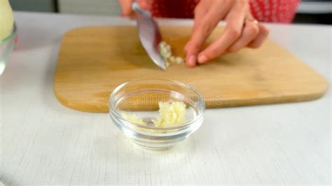 Chef Woman Hands Adding Chopped Garlic To Glass Bowl Cooking on Kitchen ...