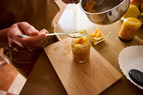 Person Preparing Homemade Fruit Jam in Jars on a Kitchen Countertop ...