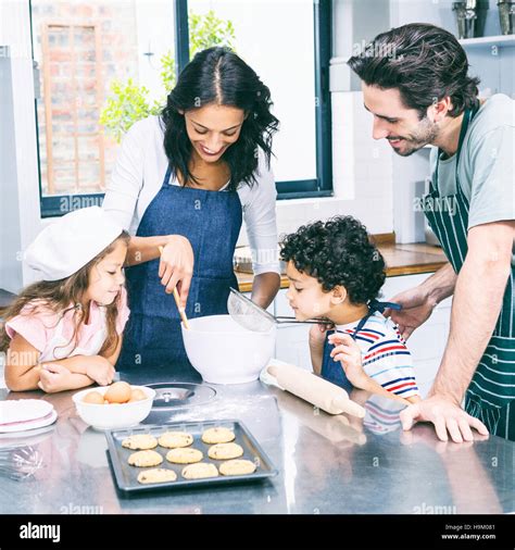 Happy family cooking biscuits together Stock Photo - Alamy