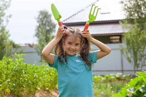 Funny Little Girl Holding Small Gardening Tools , Standing in the ...