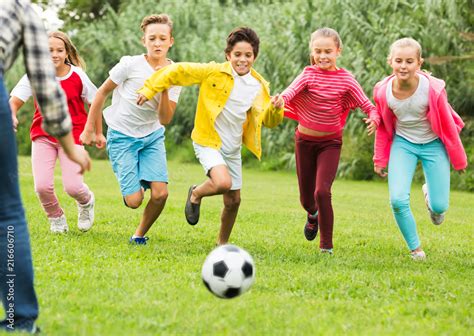 Kids playing football in park Stock Photo | Adobe Stock