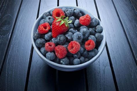 Bowl Of Summer Berries. A bowl of fresh summer berries on a black wood ...