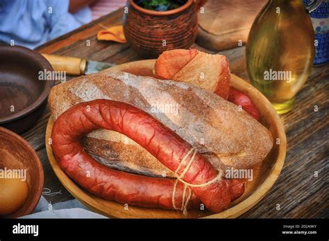 Rustic table with homemade sausage and bread. The food in vintage style ...