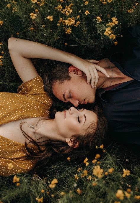 A girl and a boy laying in a field with their heads next to each other ...