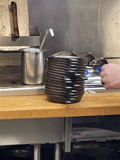 A Waffle House employee oiling cast iron skillets after they have been ...