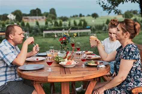 Family Having a Meal during Summer Picnic Outdoor Dinner in a Home ...