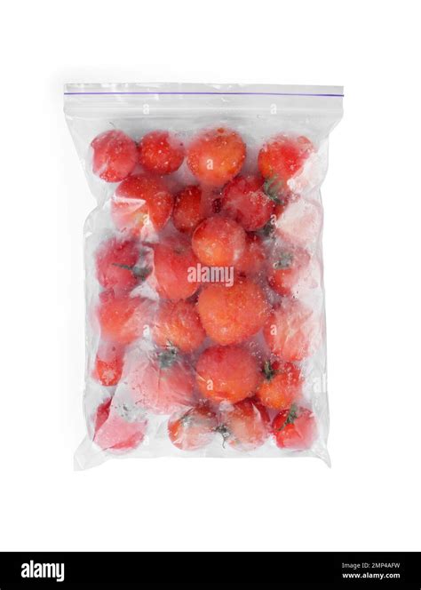 Frozen tomatoes in plastic bag isolated on white, top view. Vegetable ...