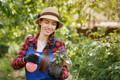 Premium Photo | Gardener spraying pesticide or water on flowers in pot