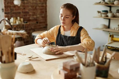 Premium Photo | Warm toned portrait of young female artisan creating ...
