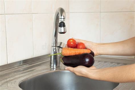 A Girl Washes Eggplant and Tomatoes and Carrots Under the Kitchen ...