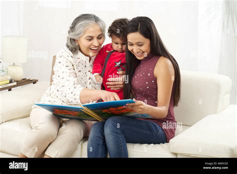 Family looking at family photo album Stock Photo - Alamy